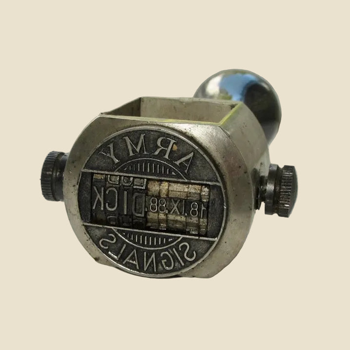 Metallic object with 'Army Signal' branding on a reflective surface