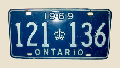 A vintage 1969 Ontario license plate with white characters and a crown emblem on a dark blue background