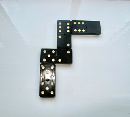 Black dominoes with white dots arranged on a white background